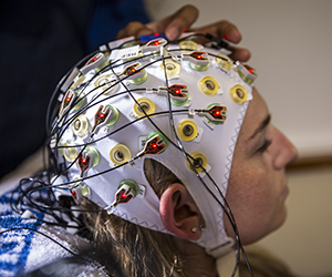 Person with EEG electrodes on head.